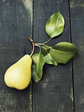 Just picked a pear on a dark wooden surface - vintage look