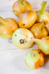various fresh onions on a wooden table. wallpaper for grocery shopping and cooking food concept