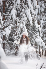 Fototapeta na wymiar Happy woman on the winter background. Young pretty girl in the woods outdoors. Portrait of a cheerful beautiful woman.