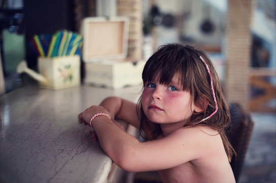 Little girl sitting at a pool bar on her holiday