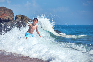 Cute Caucasian boy in sea waves. © Artem