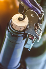 Opening a wine bottle with corkscrew