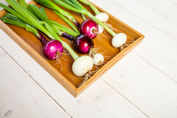 various fresh onions on a wooden table. wallpaper for grocery shopping and cooking food concept