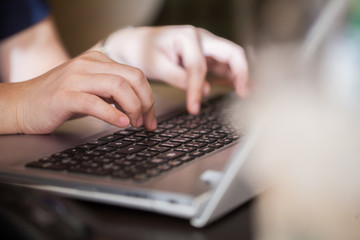 Woman hand using keyboard with blurry front and back background