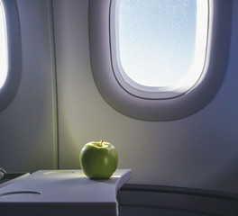 a green apple on the table of airplane