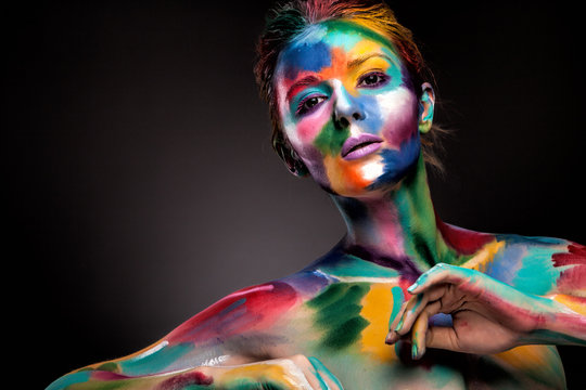 Fashion model girl portrait with colorful paint make up. Sexy woman bright color makeup. Art design. Grey background