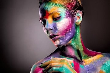 Fashion model girl portrait with colorful paint make up. Sexy woman bright color makeup. Art design. Grey background