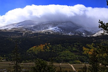 Mountain Peaks in snow lower elevations fall colors are appearing