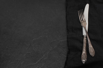 Black stone table with silverware on the linen napkin