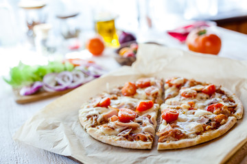 hot fresh homemade traditional italian pizza on wooden table. wallpaper for pizzeria and cooking food concept