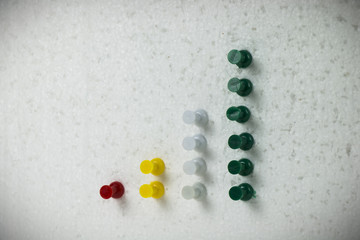 Colorful pins on polystyrene business growth chart.