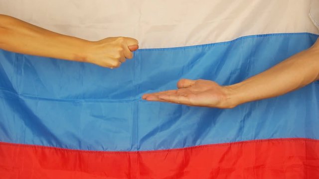 The hand on the background of the Russian flag asks for money. Fig on the background of the Russian flag.