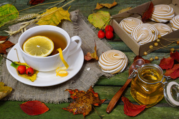 Tea, marshmallows and a jar of honey on a wooden table. Autumn still life.
