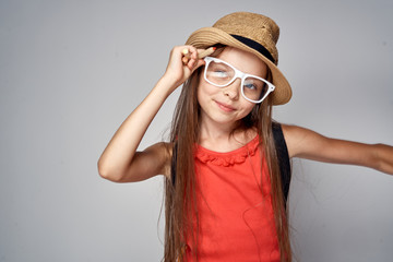 1733114 a girl in glasses fixes her hat on a gray background