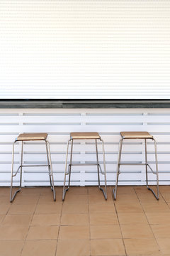 Three bar stools out side a closed bar