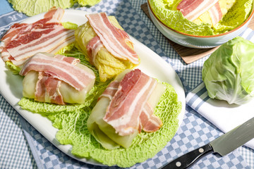 Zubereitung von Wirsingrouladen mit Speck auf Kohlblättern