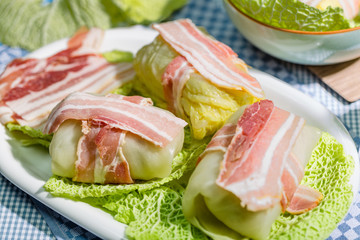 Zubereitung von Wirsingrouladen mit Speck auf Kohlblättern