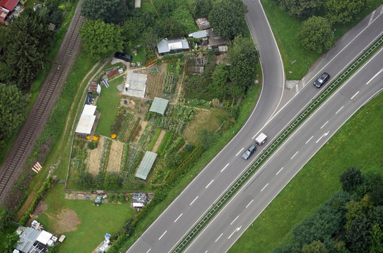 Luftaufnahme von Schrebergärten in Süddeutschland zwischen einer Landstraße und einer Bahnlinie 