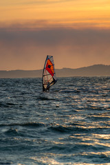 Naklejka premium Sunset over the sea or ocean and extreme freestyle sport windsurfing