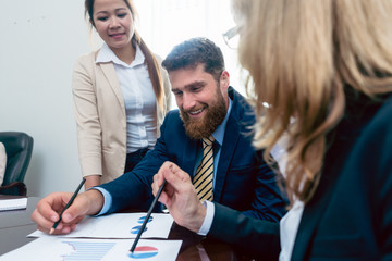 Business analyst smiling while interpreting financial reports showing profit and development during...
