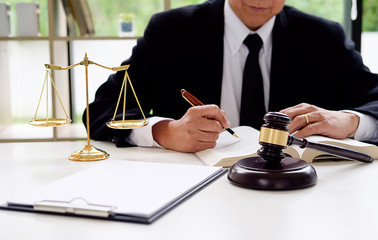 Judge gavel with Justice lawyers having team meeting at law firm in background. Concepts of law.