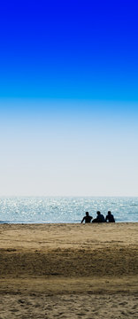 Vertical Three Freinds Sitting On The Ocean Beach Background Bac