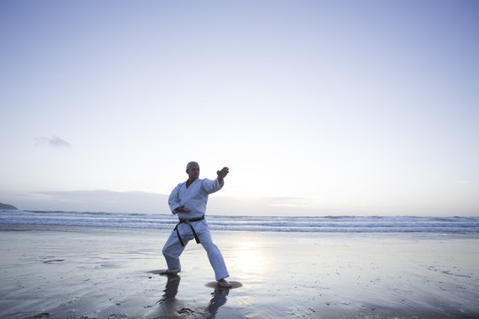 Karate Master training alone on beach.
