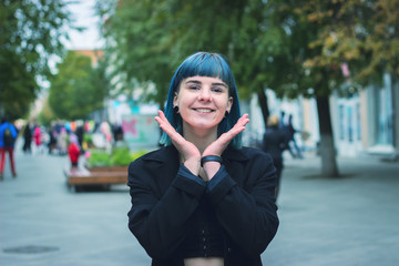 Young, beautiful woman with blue hair is smiling