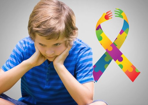 Boy against grey background with autism color spectrum hands