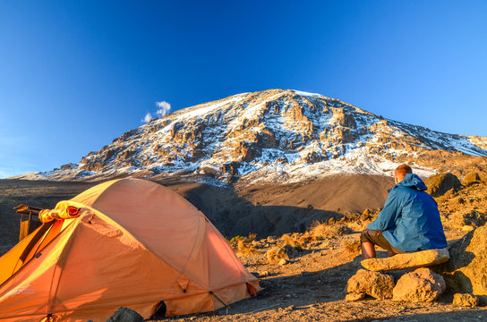 Fototapeta Evening view of Kibo with Uhuru Peak (5895m amsl, highest mountain in Africa) at Mount Kilimanjaro,Kilimanjaro National Park,seen from Karanga Camp at 3995m amsl. Tent and young hiker in foreground.