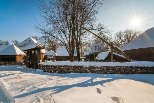 Sun shines over a traditional Romanian Village in winter at the Village Museum in Bucharest. 