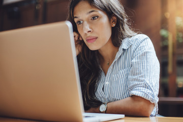 Portrait of confident woman working on laptop