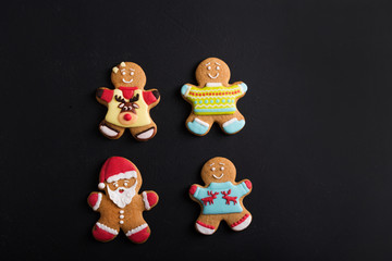  Ginger men with colored  glaze on a black background . Gingerbread. Christmas cookies.