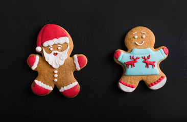  Ginger men with colored  glaze on a black background . Gingerbread. Christmas cookies.