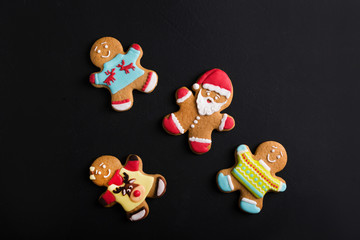  Ginger men with colored  glaze on a black background . Gingerbread. Christmas cookies.