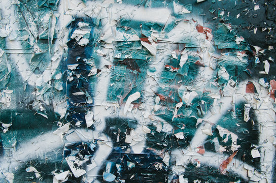 staples and remnants of posters on a painted wall