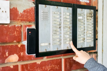 Young girl talking on the intercom and presses the button