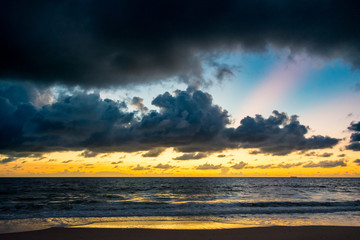 Fototapeta premium colored cloud layers over the ocean on a warm morning at the beach