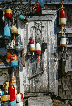 colorful lobster buoys on the wooden wall of the house. fishing wooden house with nets and buoys. vertical