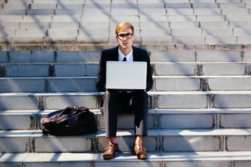 Smart Businessman Using Laptop for His Work Outdoor Sitting on the Stairs
