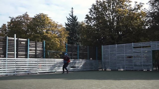 Slow motion of two men practising ball passing while playing American football on field