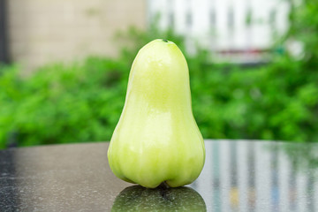 green rose apple on black marble. outdoor. garden. day