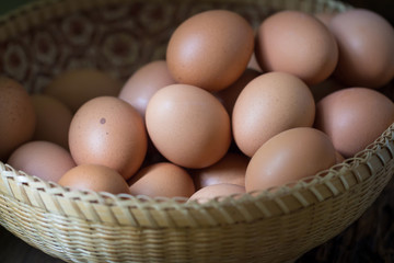 Close up of eggs in a basket on wooden table background