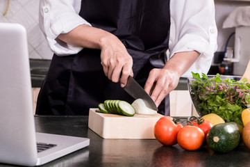 Healthy Woman makes fresh vegetable salad with olive oil, tomato and salad.