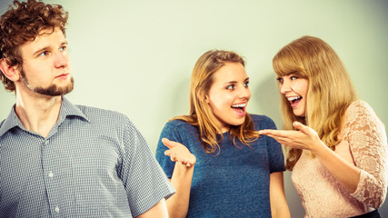 Two women talking gossiping about man.