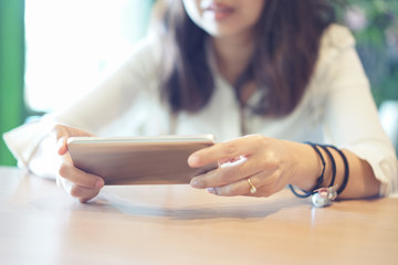 Women's hands holding smartphone in coffee shop place
