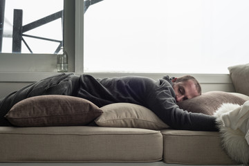 man asleep on couch in ski chalet