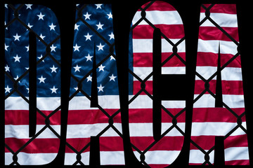 DACA bold letters with american flag and chain link fence in the background - 177863823