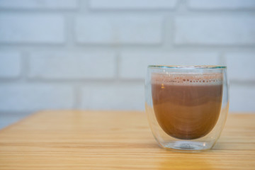 Mug of hot chocolate on wooden table in cafe