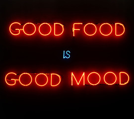 Obraz premium Illuminated neon sign showing good food is good mood on black background